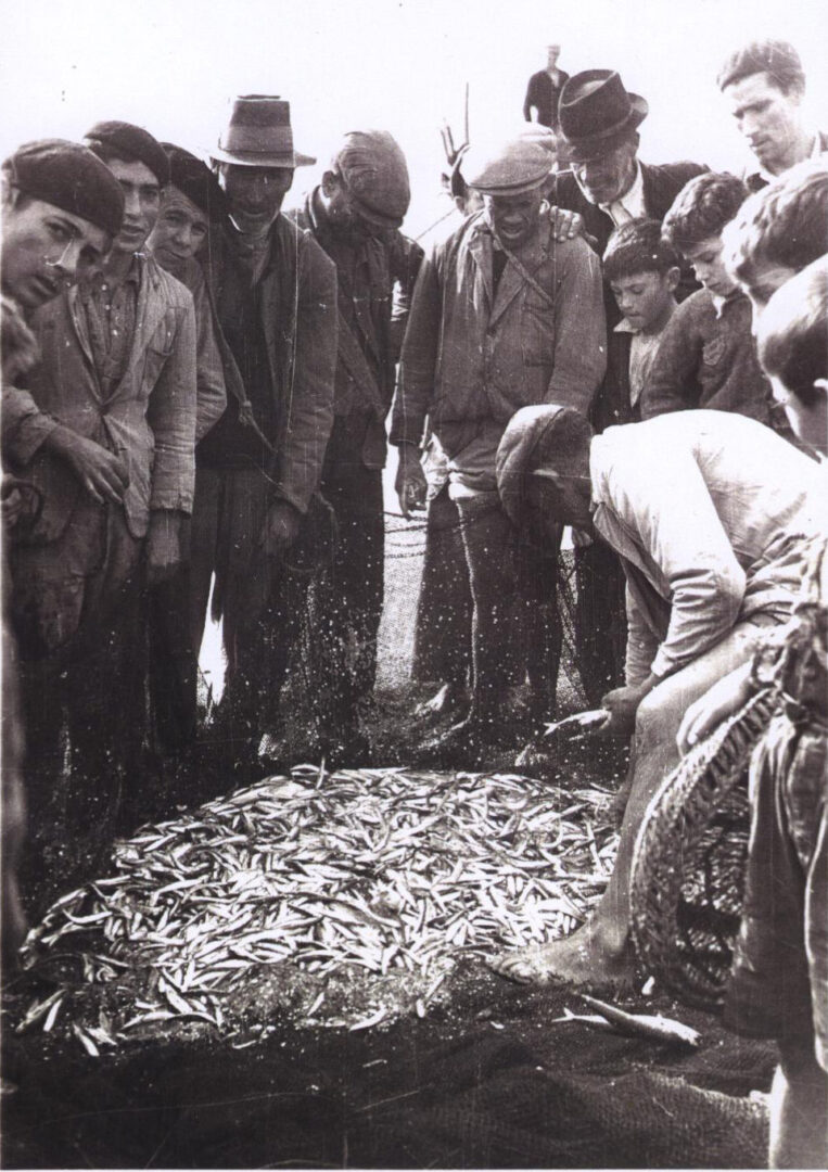 Dès que la ligne est récupérée, au milieu du nuage d'écailles que le poisson libère, vient le moment de la garfa. Photo : Fonds Miguel López Castro.